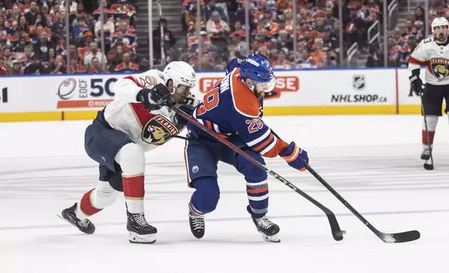 Florida Panthers' Tomas Nosek (92) and Edmonton Oilers' Connor Brown (28) battle for the puck during the second period in Game 1 of the NHL hockey Stanley Cup final series in Edmonton, Alberta, Wednesday, June 4, 2025. (Jason Franson/The Canadian Press via AP)