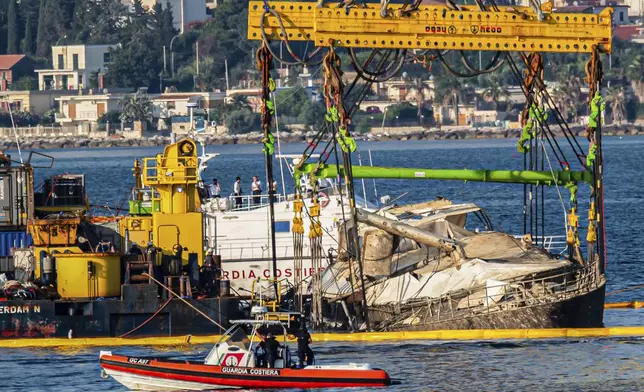 The hull of the superyacht Bayesian, which sank near Palermo, Sicily, on August 19, 2024, is lifted by cranes during salvage operations off the village of Porticello Saturday, June 21, 2025. (AP Photo/Salvatore Cavalli)