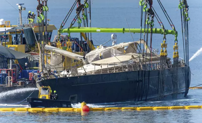 The hull of the superyacht Bayesian, which sank near Palermo, Sicily, on August 19, 2024, is pulled out of the sea and dewatered off the village of Porticello Saturday, June 21, 2025. (AP Photo/Salvatore Cavalli)