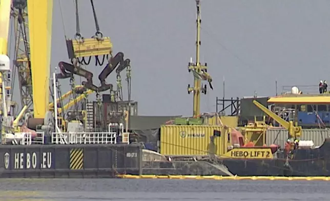 The hull of the superyacht Bayesian, which sank near Palermo, Sicily, on August 19, 2024, is lifted by cranes during salvage operations off the village of Porticciolo on Friday, June 20, 2025. (Rosalia Bonfardino)