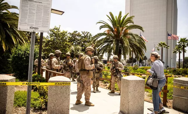 Members of the California National Guard and U.S. Marines, guard the entrance outside the Wilshire Federal Building, ahead of Saturday's nationwide "No Kings Day" protest, in Los Angeles, Calif., Friday, June 13, 2025. (Stephen Lam/San Francisco Chronicle via AP)