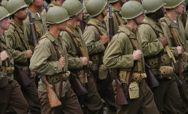 Soldiers from the 82nd Airborne Division, dress in World War II era uniforms, march past the reviewing stand with President Donald Trump during a military parade commemorating the Army's 250th anniversary, coinciding with his 79th birthday, Saturday, June 14, 2025, in Washington. (AP Photo/Julia Demaree Nikhinson)