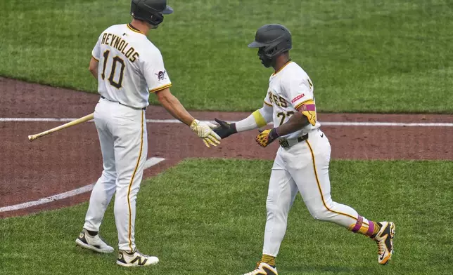 Pittsburgh Pirates' Andrew McCutchen, right, is greeted by Bryan Reynolds (10) as he returns to the dugout after hitting a sacrifice fly off Houston Astros pitcher Ryan Gusto, driving in a run, during the second inning of a baseball game in Pittsburgh, Wednesday, June 4, 2025. (AP Photo/Gene J. Puskar)