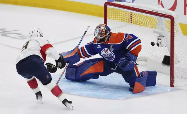 Florida Panthers' Sam Bennett (9) scores on Edmonton Oilers goalie Stuart Skinner (74) during the second period in Game 1 of the NHL hockey Stanley Cup final series in Edmonton, Alberta, Wednesday, June 4, 2025. (Darryl Dyck/The Canadian Press via AP)