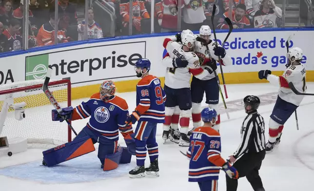 Florida Panthers' Sam Bennett (9), Carter Verhaeghe (23), Niko Mikkola (77) and Matthew Tkachuk (19) celebrate a goal against Edmonton Oilers goalie Stuart Skinner (74) as Jake Walman (96) and Brett Kulak (27) look on during the first period in Game 1 of the NHL Stanley Cup Final, in Edmonton, Alberta, on Wednesday, June 4, 2025. (Darryl Dyck/The Canadian Press via AP)