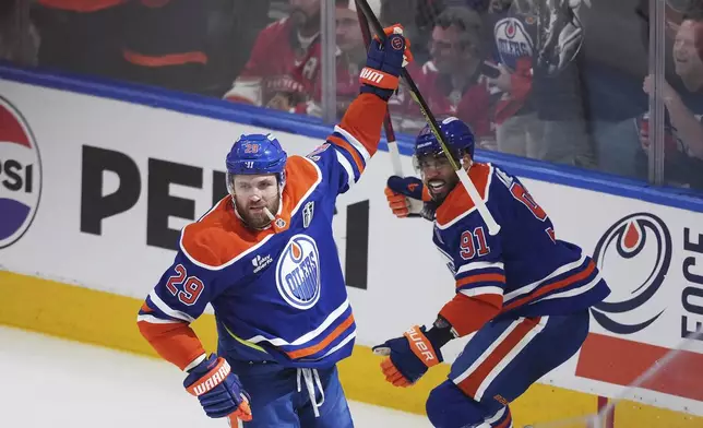 Edmonton Oilers' Leon Draisaitl, left, celebrates his goal against the Florida Panthers with Evander Kane during the first period in Game 1 of the NHL hockey Stanley Cup Finals, in Edmonton, Alberta, Wednesday, June 4, 2025. (Darryl Dyck/The Canadian Press via AP)