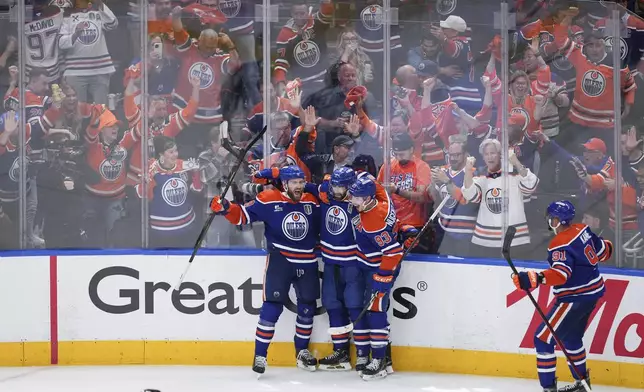 Edmonton Oilers' Leon Draisaitl, from left to right, Evan Bouchard, Ryan Nugent-Hopkins and Evander Kane celebrate Draisaitl's winning goal during the first overtime period in Game 1 of the NHL Stanley Cup Final against the Florida Panthers, in Edmonton, Alberta, on Wednesday, June 4, 2025. (Darryl Dyck/The Canadian Press via AP)