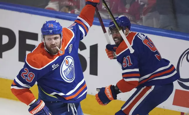 Edmonton Oilers' Leon Draisaitl, left, celebrates his goal against the Florida Panthers with Evander Kane, right, during the first period in Game 1 of the NHL hockey Stanley Cup Finals, in Edmonton, Alberta, on Wednesday, June 4, 2025. (Darryl Dyck/The Canadian Press via AP)