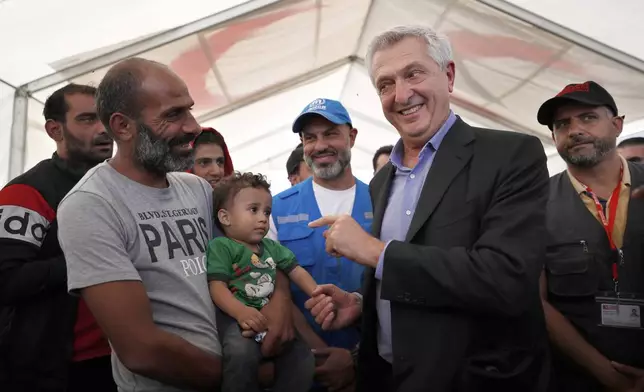UN High Commissioner for Refugees (UNHCR), Filippo Grandi, right, gestures as he talks to a man who fled the war in Lebanon at the Syrian border crossing point, in Jdeidet Yabous, Syria, Oct. 7, 2024. (AP Photo/Omar Sanadiki, File)