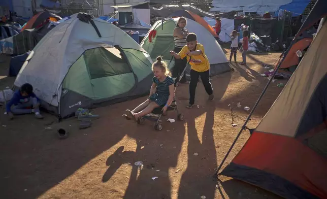 FILE - Children play at the Benito Juarez Sports Center that's serving as a temporary shelter in Tijuana, Mexico, Nov. 26, 2018, afternoon the mayor of Tijuana declared a humanitarian crisis in his border city and says that he has asked the United Nations for aid to deal with thousands of Central American migrants who have arrived in the city. (AP Photo/Ramon Espinosa, File)