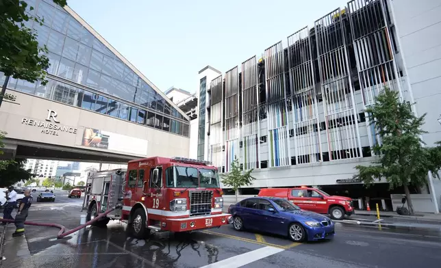 A fire truck is seen outside a parking garage where vehicles caught fire and part of a floor in the structure collapsed Tuesday, June 10, 2025, in Nashville, Tenn. (AP Photo/George Walker IV)