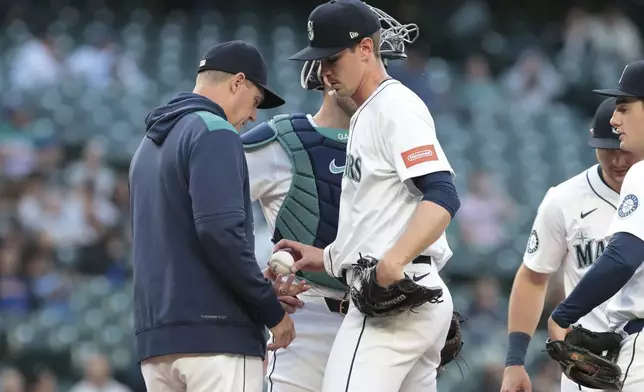 Seattle Mariners manager Dan Wilson, left, takes the ball from starting pitcher Emerson Hancock during the sixth inning of a baseball game against the Baltimore Orioles, Wednesday, June 4, 2025, in Seattle. (AP Photo/Jason Redmond)