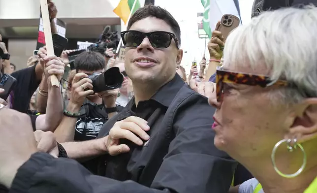 Naoise O Caireallain, a member of the Irish language band Kneecap, arrives at Westminster Magistrates Court in London, Wednesday, June 18, 2025, to support fellow band member Liam Óg Ó hAnnaidh, who is charged with a terrorism offence relating to displaying a flag in support of Hezbollah during a performance with the band in November 2024. (AP Photo/Kin Cheung)