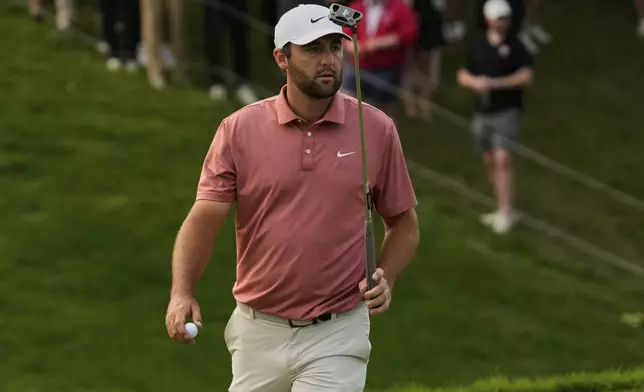 Scottie Scheffler gestures after his putt on the 18th green during the third round of the Memorial golf tournament Saturday, May 31, 2025, in Dublin, Ohio. (AP Photo/Sue Ogrocki)