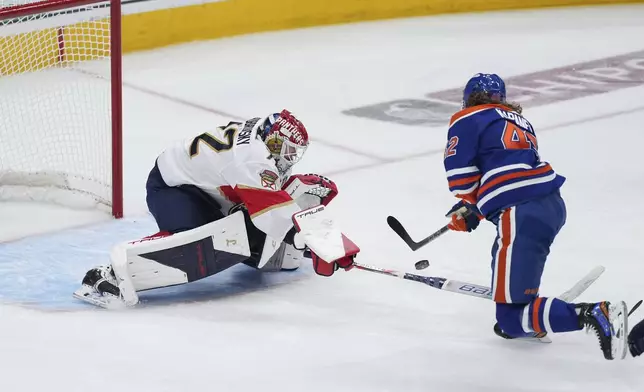 Edmonton Oilers' Kasperi Kapanen, right, puts a shot wide of the net as Florida Panthers goalie Sergei Bobrovsky poke-checks him during the first overtime period in Game 1 of the NHL Stanley Cup Final, in Edmonton, Alberta, on Wednesday, June 4, 2025. (Darryl Dyck/The Canadian Press via AP)