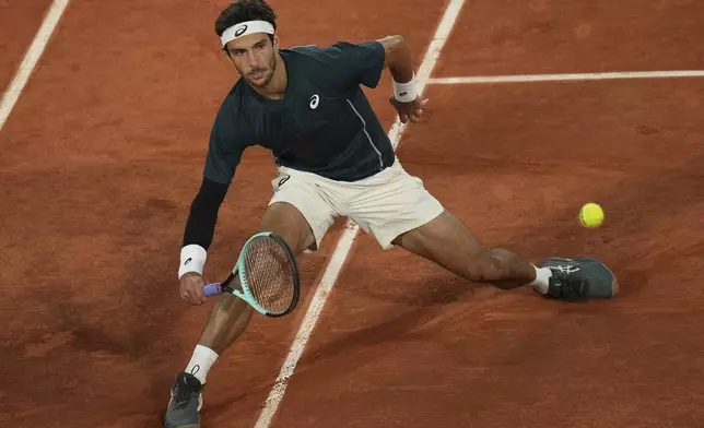 Italy's Lorenzo Musetti returns the ball to Denmark's Holger Rune during their fourth round match of the French Tennis Open, at the Roland-Garros stadium, in Paris, Sunday, June 1 2025. (AP Photo/Christophe Ena)