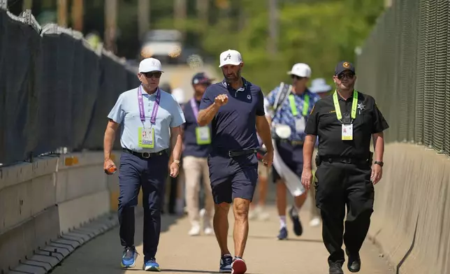 Dustin Johnson uses a pedestrian bridge over the Pennsylvania Turnpike, which divides Oakmont Country Club, during a practice round ahead of the U.S. Open golf tournament Wednesday, June 11, 2025, in Oakmont, Pa. (AP Photo/Carolyn Kaster)