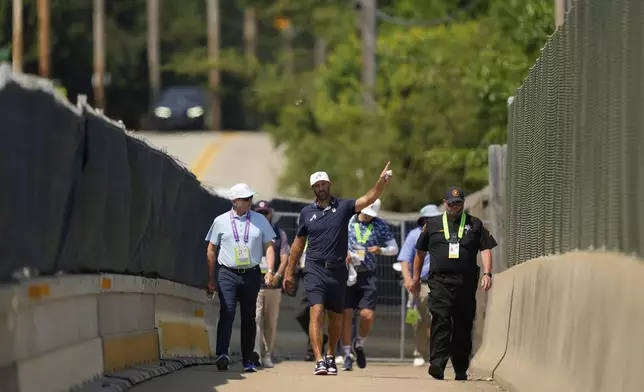Dustin Johnson uses a pedestrian bridge over the Pennsylvania Turnpike, which divides Oakmont Country Club, during a practice round ahead of the U.S. Open golf tournament Wednesday, June 11, 2025, in Oakmont, Pa. (AP Photo/Carolyn Kaster)