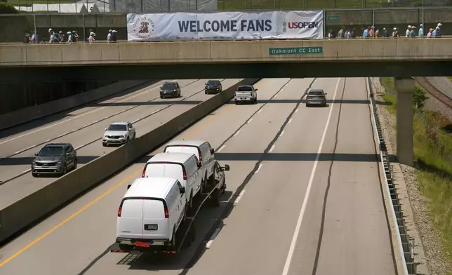 Vehicles travel along the Pennsylvania Turnpike passing under a pedestrian bridge splitting Oakmont Country Club during a practice round ahead of the U.S. Open golf tournament Wednesday, June 11, 2025, in Oakmont, Pa. (AP Photo/Charlie Riedel)