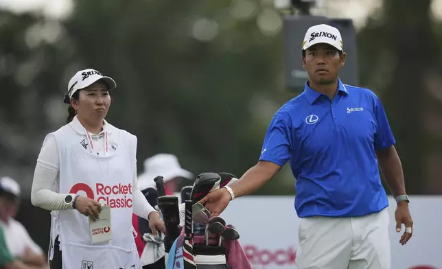 Hideki Matsuyama, of Japan, right, waits with his caddie Mei Inui at the ninth tee during the first round of the Rocket Classic golf tournament at the Detroit Golf Club, Thursday, June 26, 2025, in Detroit. (AP Photo/Paul Sancya)