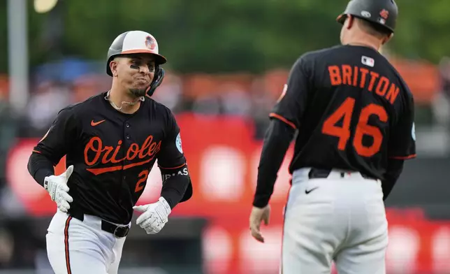 Baltimore Orioles' Ramon Urias, left, celebrates with interim third base/infield coach Buck Britton (46) after hitting a two-run home run during the third inning of a baseball game against the Detroit Tigers, Wednesday, June 11, 2025, in Baltimore. (AP Photo/Stephanie Scarbrough)