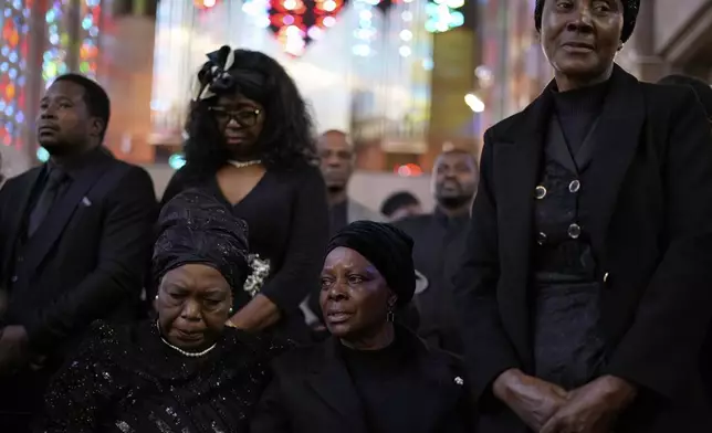 Esther Lungu, widow of Zambia's former President Edgar Lungu, center, and family members attend a Mass, at the Cathedral of Christ the King, in Johannesburg, South Africa, Wednesday, June 25, 2025. (AP Photo/Themba Hadebe)