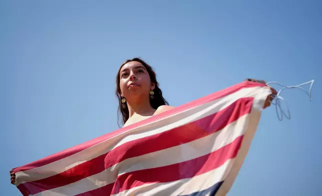 A protester holds and national flag upside down, Monday, June 9, 2025, in downtown Los Angeles. (AP Photo Eric Thayer)