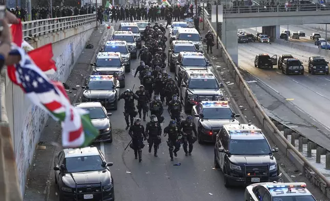 Officers make their way down a ramp to the 101 Freeway near the metropolitan detention center of downtown Los Angeles, Sunday, June 8, 2025, following last night's immigration raid protest. (AP Photo/Jae C. Hong)
