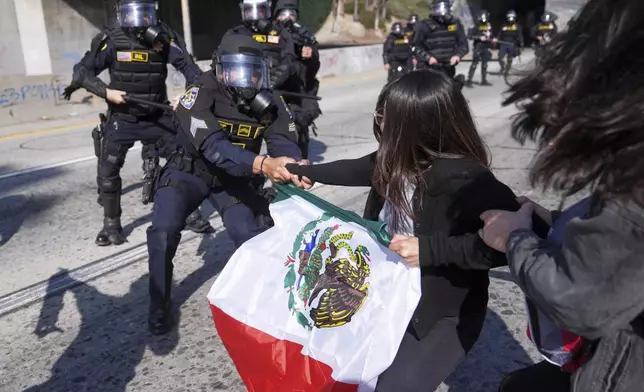 Protesters confront police on the 101 Freeway near the metropolitan detention center of downtown Los Angeles, Sunday, June 8, 2025, following last night's immigration raid protest. (AP Photo/Jae C. Hong)