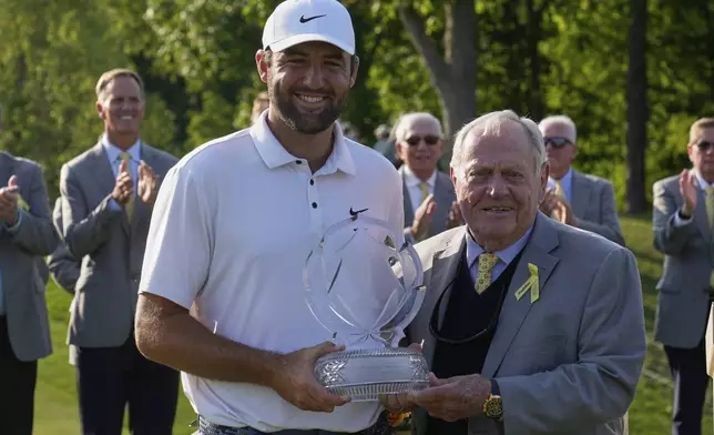 Scottie Scheffler, left, and Jack Nicklaus, right, pose with the trophy after Scheffler won the Memorial golf tournament Sunday, June 1, 2025, in Dublin, Ohio. (AP Photo/Sue Ogrocki)