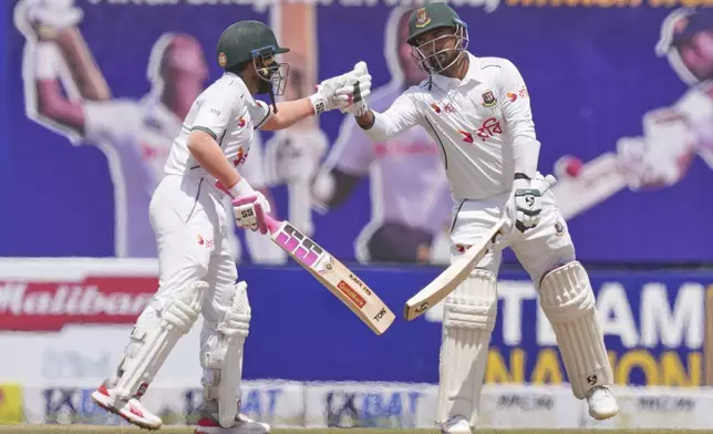 Bangladesh's Mushfiqur Rahim, left, congratulates Litton Das for scoring a fifty runs during the second day of the first cricket test match between Sri Lanka and Bangladesh in Galle, Sri Lanka, Wednesday, June 18, 2025. (AP Photo/Eranga Jayawardena)