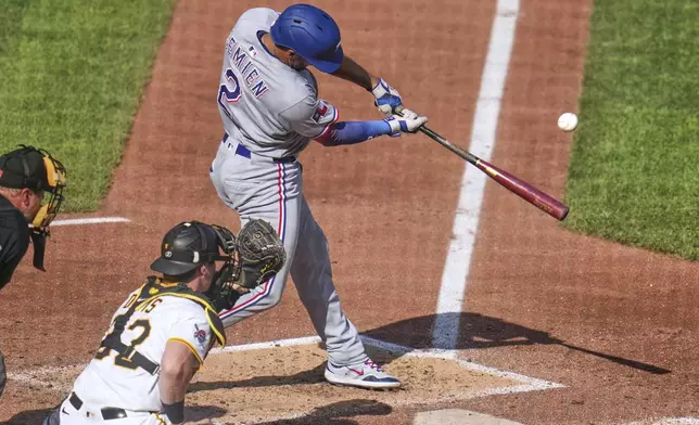 Texas Rangers' Marcus Semien (2) drives in a run with a sacrifice fly off Pittsburgh Pirates pitcher Mitch Keller during the sixth inning of a baseball game in Pittsburgh, Saturday, June 21, 2025. (AP Photo/Gene J. Puskar)