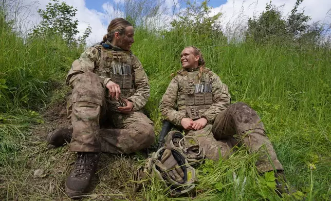 20-year-old conscript Katrine, right, speaks with another female conscript during final exercises at a training area close to Royal Danish Army’s barracks in Hovelte, 25 kilometres north of Copenhagen, Denmark, Wednesday, June 11, 2025. (AP Photo/James Brooks)