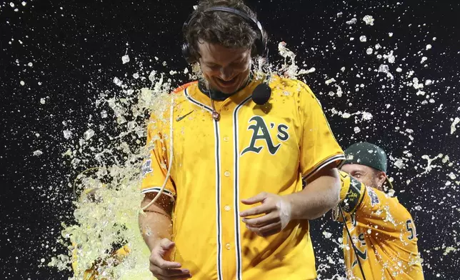 Athletics' Nick Kurtz is splashed by gatorade after he hits a walk off two run home run against the Houston Astros during the 10th inning of a baseball game Thursday, June 19, 2025, in West Sacramento, Calif. (AP Photo/Scott Marshall)