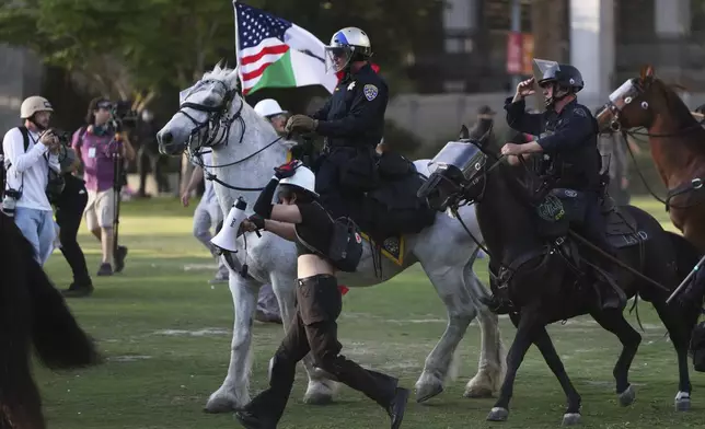 Los Angeles Metro police on horseback disperse protesters on Wednesday, June 11, 2025, in Los Angeles. (AP Photo/Ethan Swope)