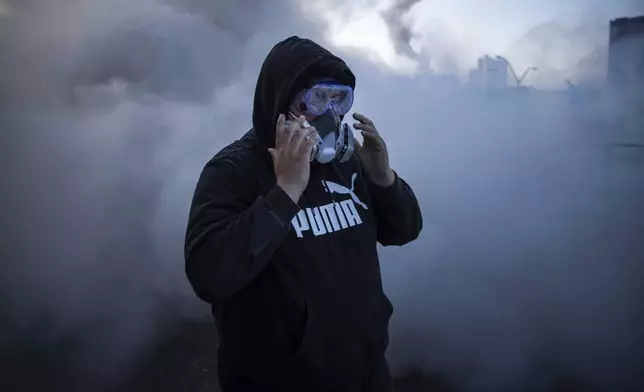 A person reacts to irritants during protests near the Metropolitan Detention Center in downtown Los Angeles, Sunday, June 8, 2025. (AP Photo/Ethan Swope)