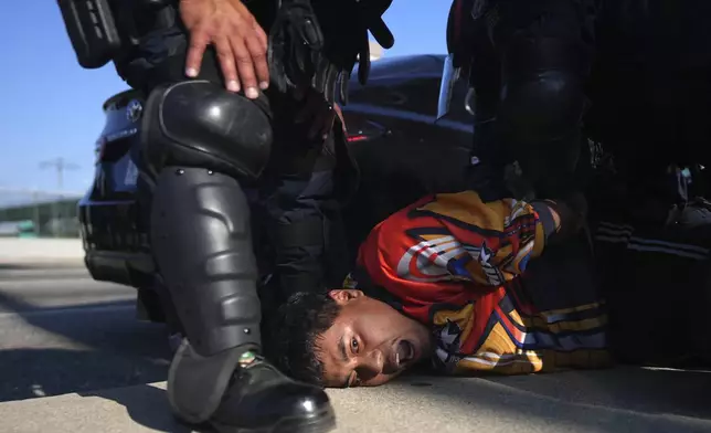 A protester is arrested by California Highway Patrol near the federal building in downtown Los Angeles on Tuesday, June 10, 2025. (AP Photo/Eric Thayer)