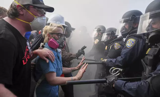 Protesters confront police on the 101 Freeway near the Metropolitan Detention Center of downtown Los Angeles, Sunday, June 8, 2025, following last night's immigration raid protest. (AP Photo/Jae C. Hong)