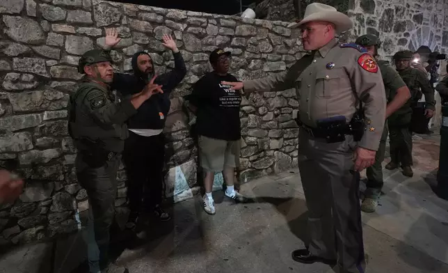 An anti ICE protesters is detained by Texas state troopers near the Alamo in downtown San Antonio, Wednesday, June 11, 2025. (AP Photo/Eric Gay)