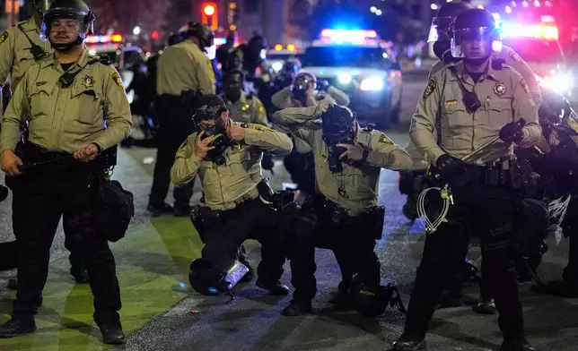 Las Vegas police don gas masks during protests over President Donald Trump's stepped-up enforcement of immigration laws, Wednesday, June 11, 2025, in Las Vegas. (AP Photo/John Locher)