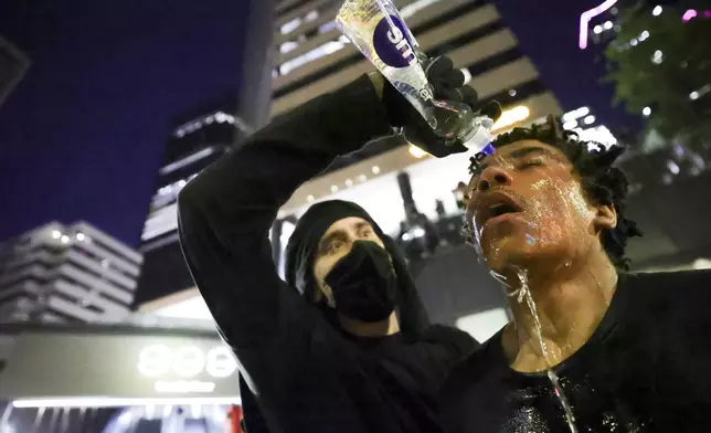 A protestor reacts after being pepper sprayed during a protest against federal immigration arrests, Wednesday, June 11, 2025, in Seattle. (AP Photo/Ryan Sun)