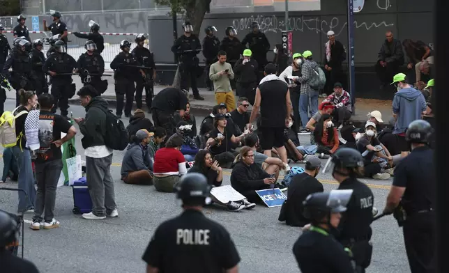 Los Angeles police officers surround protesters under arrest on Wednesday, June 11, 2025, in Los Angeles. (AP Photo/Ethan Swope)