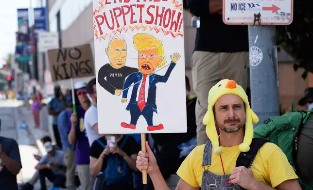 Protesters against federal immigration raids gather outside the Metropolitan Detention Center, Wednesday, June 11, 2025, in Los Angeles. (AP Photo/Damian Dovarganes)