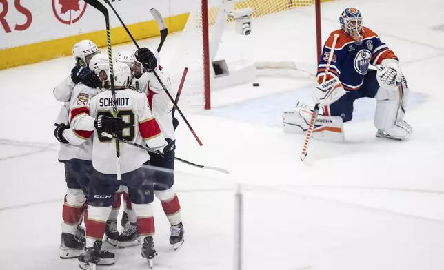Florida Panthers players, left, celebrate after a goal as Edmonton Oilers' goalie Calvin Pickard (30) looks on during the first period in Game 5 of the NHL hockey Stanley Cup Final in Edmonton, Alberta, Saturday, June 14, 2025. (Jason Franson/The Canadian Press via AP)