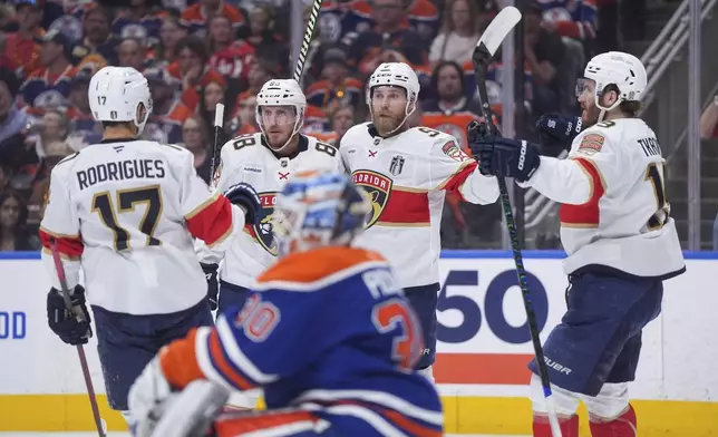Florida Panthers' Sam Bennett (9) celebrates after his goal with teammates, from back left to right, Evan Rodrigues, Nate Schmidt and Matthew Tkachuk as Edmonton Oilers goalie Calvin Pickard, foreground, looks on during the first period in Game 5 of the NHL hockey Stanley Cup Final in Edmonton, Alberta, Saturday, June 14, 2025. (Darryl Dyck/The Canadian Press via AP)