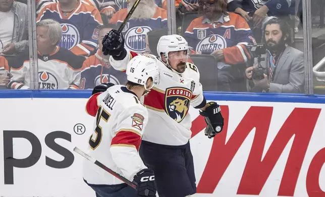 Florida Panthers' Anton Lundell (15) and Brad Marchand (63) celebrate after a goal against the Edmonton Oilers during the third period in Game 5 of the NHL hockey Stanley Cup Final in Edmonton, Alberta, Saturday, June 14, 2025. ( Jason Franson/The Canadian Press via AP)