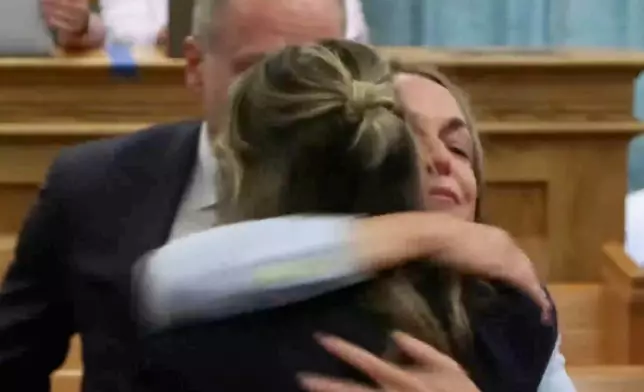 In this image made from pool video, Karen Read, right, hugs her legal team after the jury found her not guilty of second-degree murder during her retrial, Wednesday, June 18, 2025, in Dedham, Mass. (Pool via AP)