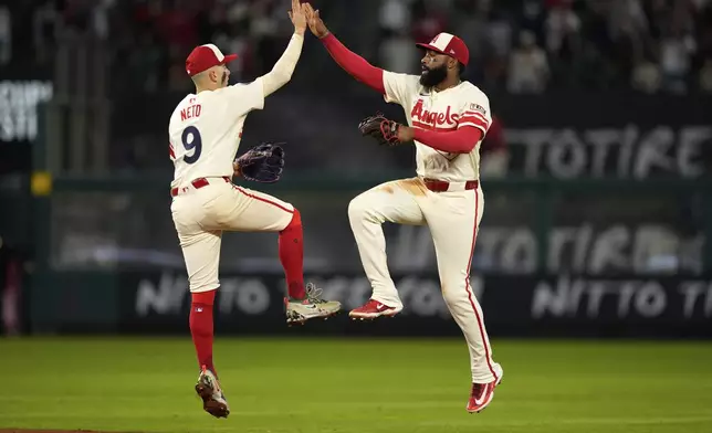 Los Angeles Angels' Zach Neto, left, and Jo Adell congratulate each other after the Angels defeated the Seattle Mariners 8-6 in a baseball game Saturday, June 7, 2025, in Anaheim, Calif. (AP Photo/Mark J. Terrill)