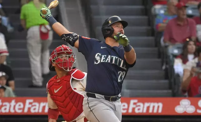 Seattle Mariners' Cal Raleigh, right, hits a two-run home run as Los Angeles Angels catcher Logan O'Hoppe watches during the first inning of a baseball game Saturday, June 7, 2025, in Anaheim, Calif. (AP Photo/Mark J. Terrill)