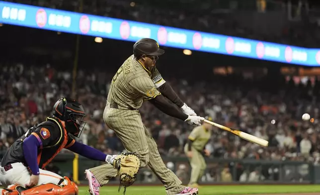San Diego Padres' Manny Machado hits a two-run single during the ninth inning of a baseball game against the San Francisco Giants, Tuesday, June 3, 2025, in San Francisco. (AP Photo/Godofredo A. Vásquez)